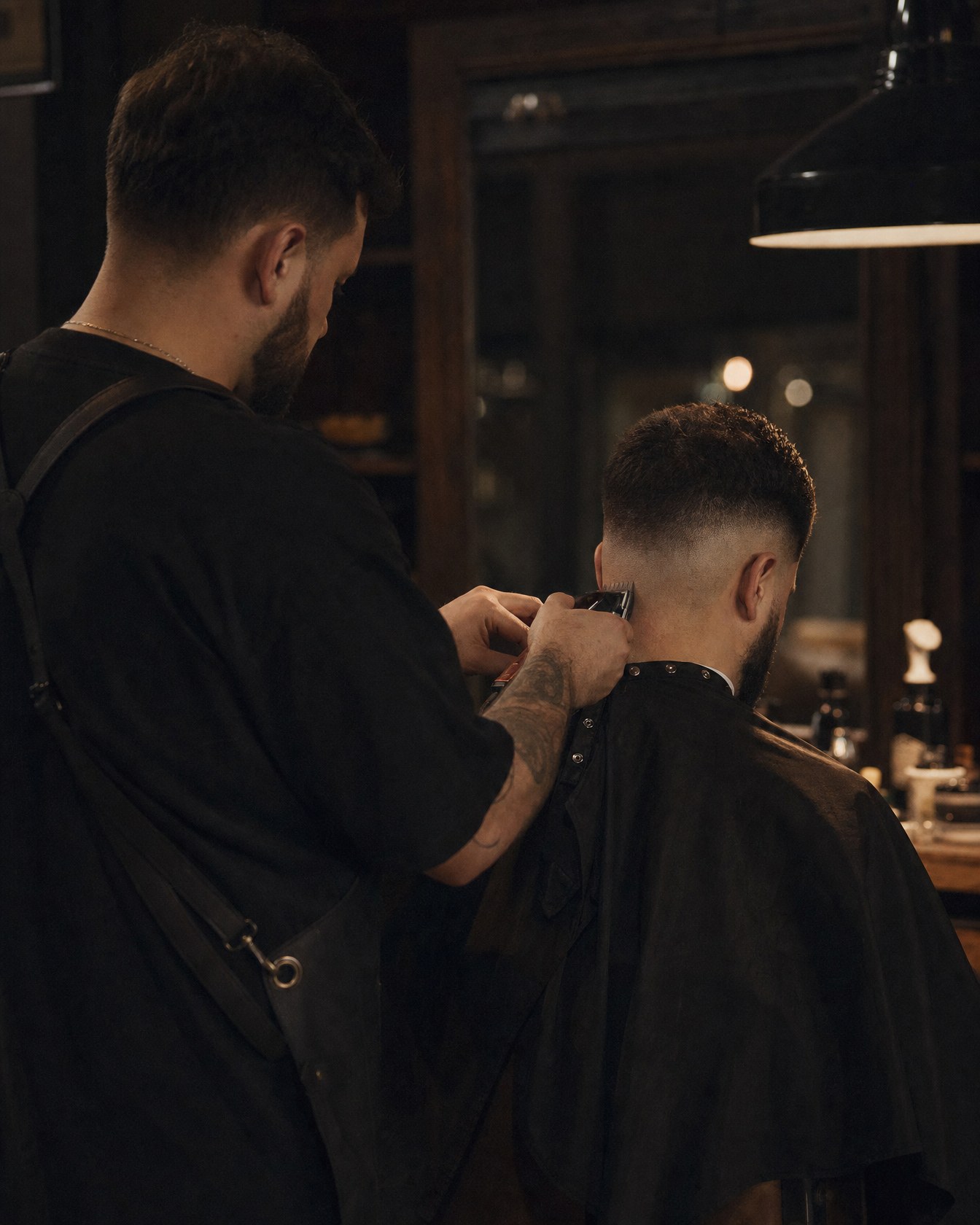 A barber at Halloran working a skin fade with clippers